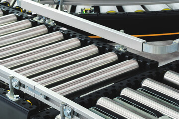 Conveyor belt with a silver and black color. The conveyor belt is made of metal and has a silver color.