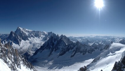 Obraz premium Expansive vista of snow-capped mountain peaks under a vibrant blue sky.
