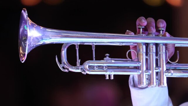 close-up of mariachi playing the trumpet with bokeh lights in the background