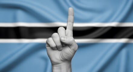 A hand pointing one finger up against a waving flag of Botswana.