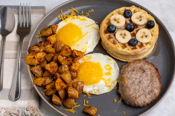 fried eggs along with waffles and home fries