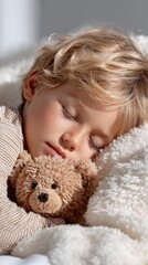 Peaceful young boy sleeping with teddy bear in cozy blanket. Childhood, dreaming, relaxation. 