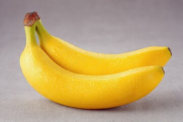 Freshly picked golden bananas glistening with droplets of water showcasing their natural texture and vibrant color against a neutral backdrop evoking freshness and vitality