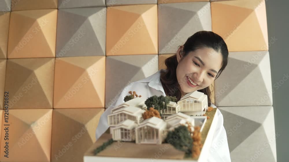 Poster skilled attractive architect engineer holds architect model while checking mistake point carefully. 
