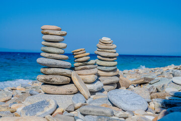 Peeble beach in samos greece, pile of rocks in front of turquoise water