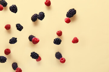 Blackberry and raspberry flying on beige background, closeup