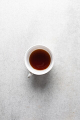 Overhead view of cup with coffee on a white background