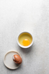 Overhead view of raw egg, whole raw egg in a glass bowl