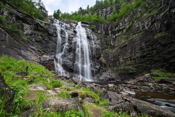 Waterfall cascades down a rocky cliff face.