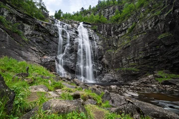 Fototapete Wald Fluss Waterfall cascades down a rocky cliff face.  © Taha