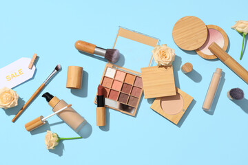 Composition with different decorative cosmetics, sale tag and flowers on color background