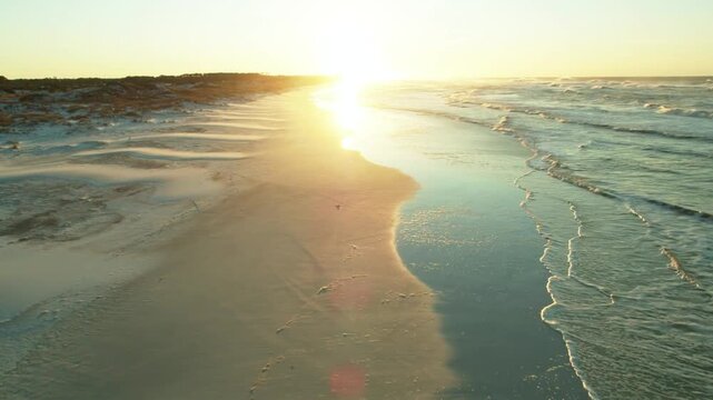 The sun rises over the sandy beach in gulf shores, alabama