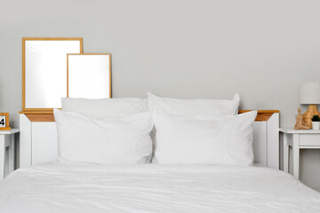 Cozy bed with white blanket and soft pillows in stylish bedroom, closeup