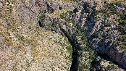 Obraz premium Aerial view of the narrow gorges and ravines created by the Amadorio River as it passes through the village of Relleu, Spain.