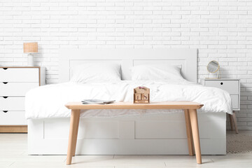 Wooden cube calendar with magazines on bedside bench in bedroom