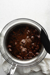 Overhead view of Dark chocolate ganache being melted in a glass bowl