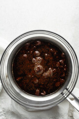 Overhead view of Dark chocolate ganache in a glass bowl, top view of chocolate ganache being melted in a double boiler