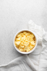 Overhead view of organic butter in a white plate with handle, natural yellow butter from grass fed cows