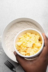 Overhead view of organic butter in a white plate with handle, natural yellow butter from grass fed cows