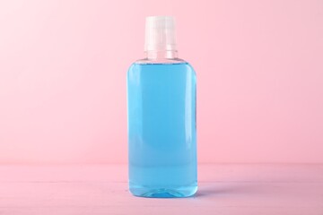 Bottle of mouthwash on pink background. Oral hygiene