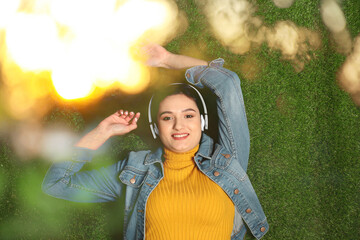 Happy woman listening to sounds of nature which making her feel calm. Bokeh effect