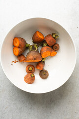 Overhead view of carrot tops for planting, top view of carrot tops on a white background