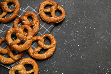 Napkin and tasty pretzels on black background, closeup