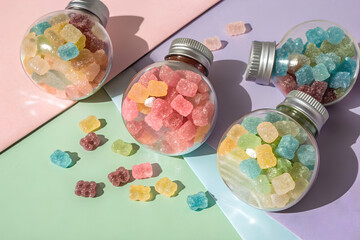 The set of four large round  bottles of frosted full of multi color candy with semi isolated background 
