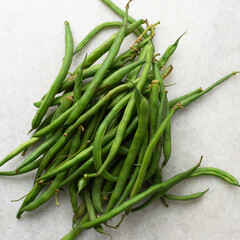Fototapeta premium Overhead view of green beans on a marble countertop, top view of green beans, haricot verts on a white countertop