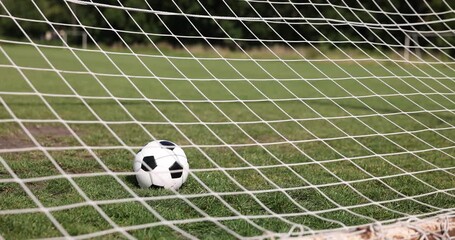 Hitting soccer ball in net outdoors, closeup. Football game - Powered by Adobe