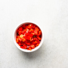 Overhead view of diced red bell peppers on marble countertop, top view of bell peppers that have been sliced