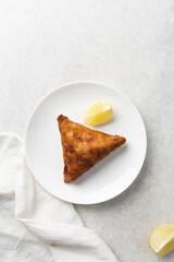 Overhead view of samosa on a white plate, top view of beef samosa on a white background