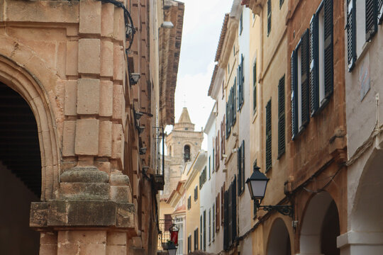 Calle estrecha y empinada en una ciudad hist&oacute;rica, con edificios a ambos lados que se elevan y convergen hacia el cielo.