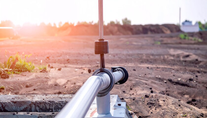 Close-Up View of an Oil Pump Jack in an Oil Field Under Sunlight with a Natural Landscape