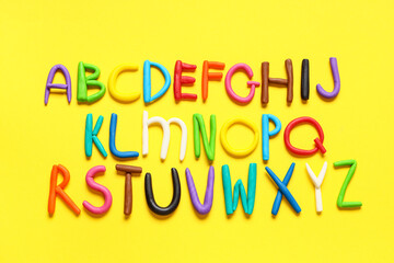English alphabet made of play dough on yellow background