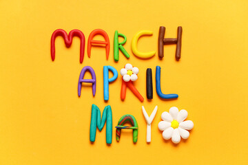 Words MARCH, APRIL, MAY made of play dough on yellow background