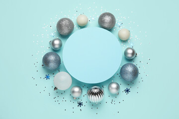 Composition with blank card, Christmas balls and confetti on blue background