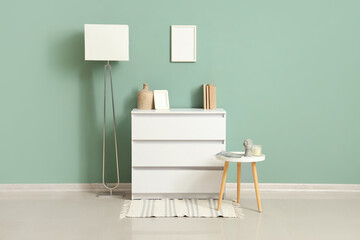 Interior of room with white commode, lamp and table