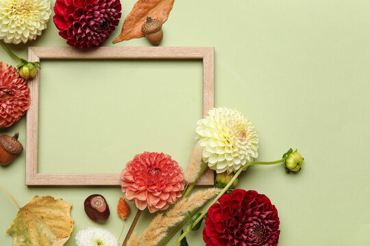 Composition with frame, beautiful dahlia flowers and dried leaves on green background - Powered by Adobe