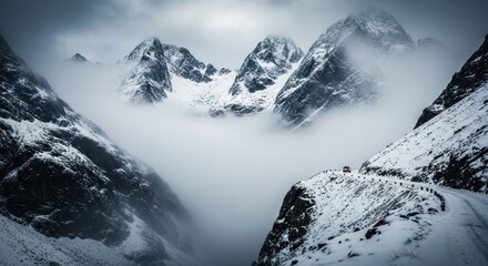 Obraz premium Epic Snow-Covered Mountains and Winding Road Through Foggy Valley with lone Vehicle