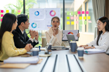 Asian businesspeople discussing charts during corporate meeting
