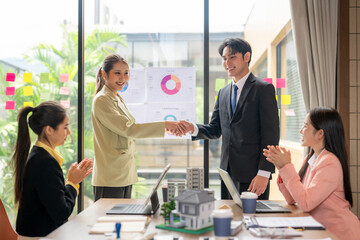 Business people shaking hands congratulating real estate project success