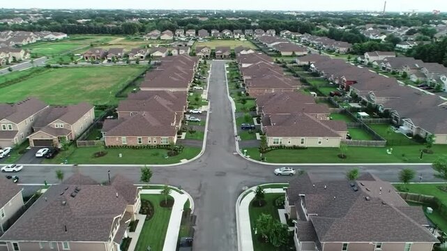 Aerial view of a suburban residential neighborhood in Stockton, California, showcasing rows of single-family homes, streets, and surrounding farmland. Ideal for topics related to urban planning, Calif