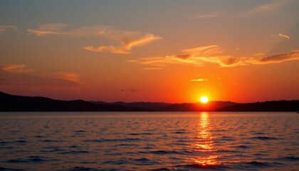 Obraz premium Vibrant orange sunset over calm waters scenic lake photography tranquil evening wide angle view nature inspiration