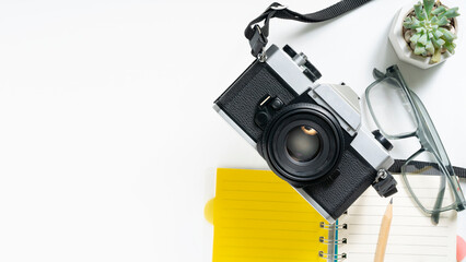 Retro camera and notepad on white background for creative planning, capturing memories and inspiration for photographers and travelers