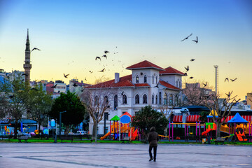 Republic Square with passerby and pigeons in early morning