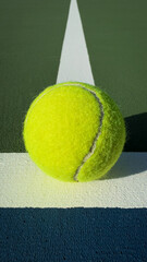 Vivid neon tennis ball centered on a green textured court under warm afternoon light, clean minimal composition with ample copy space