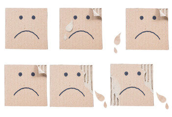 Set collection or collage of hand drawn sad face on a ripped corrugated cardboard box isolated on transparent background
