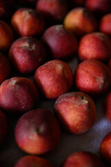 Beautiful tasty fresh peaches laying out on a table with bright red, orange and peach colors.