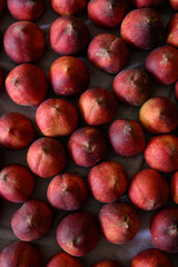 Beautiful tasty fresh peaches laying out on a table with bright red, orange and peach colors.